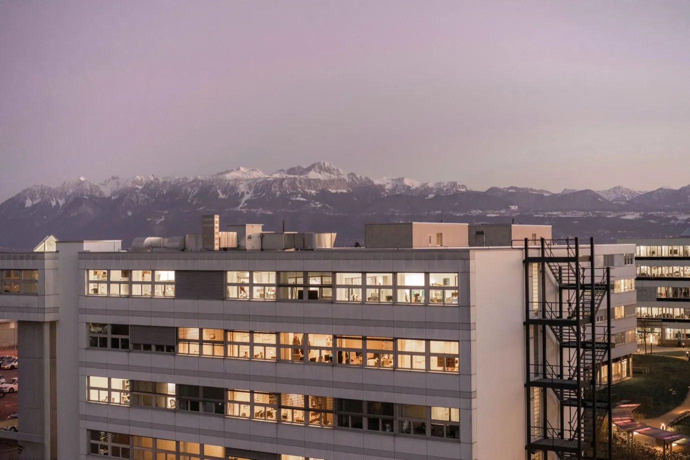 City rooftops at dusk with mountains in the background